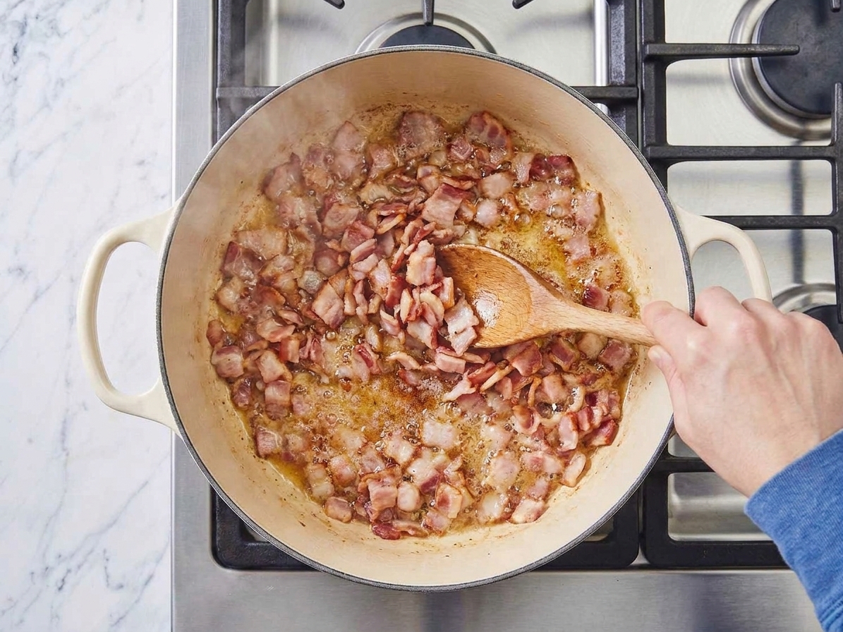 Chopped bacon sizzling in a Dutch oven on a stovetop