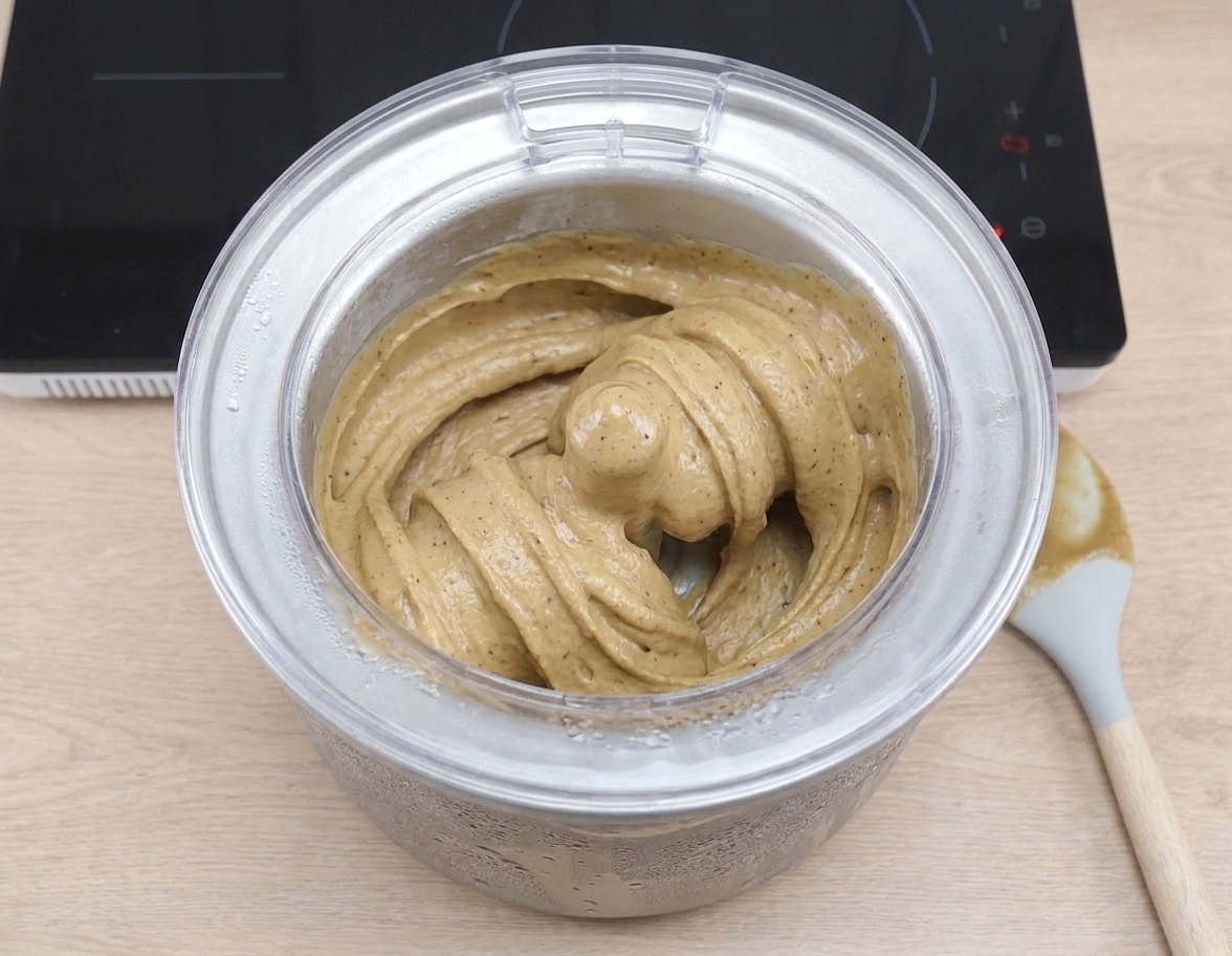 Coffee ice cream churning inside an ice cream maker bowl, thick and creamy as it spins