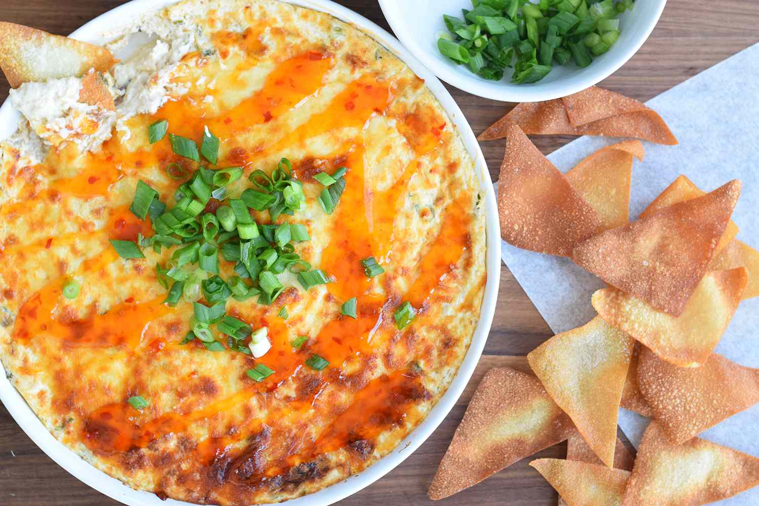 Crab rangoon dip ingredients arranged on a clean kitchen counter including cream cheese, sour cream, canned crab, shredded mozzarella, garlic, soy sauce, green onions, and a lemon