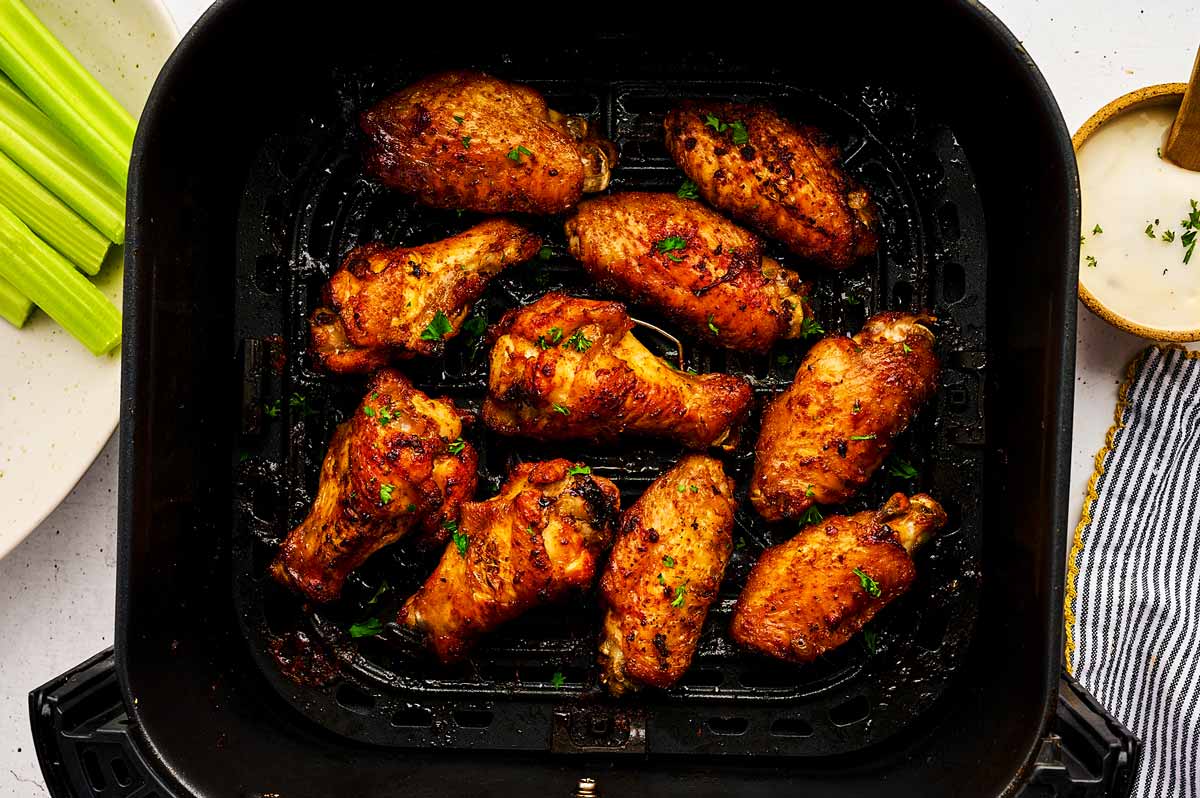 Crispy chicken wings in a single layer inside an air fryer basket