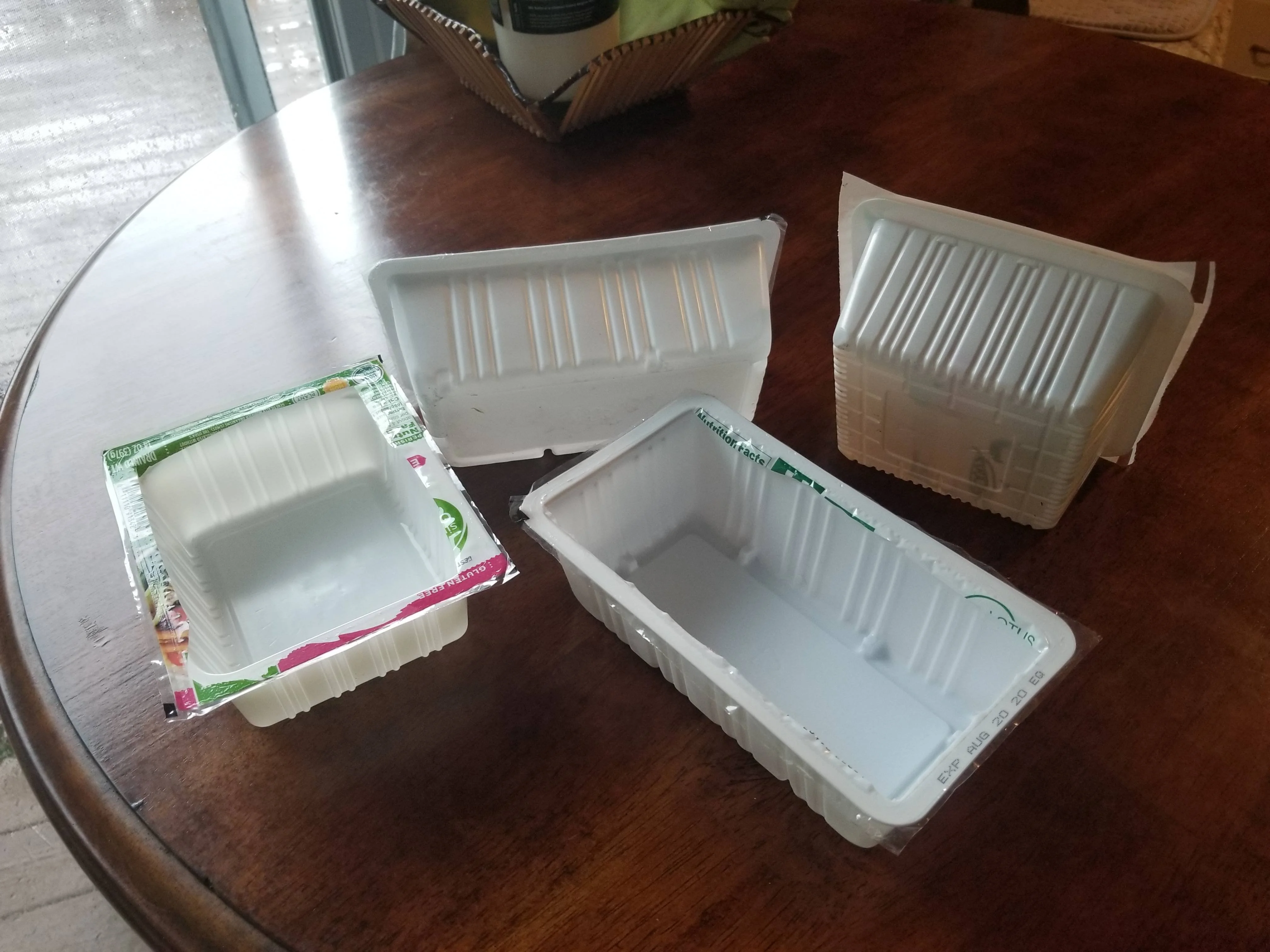 Crispy tofu pieces cooling next to an airtight glass container on a kitchen counter, ready to refrigerate