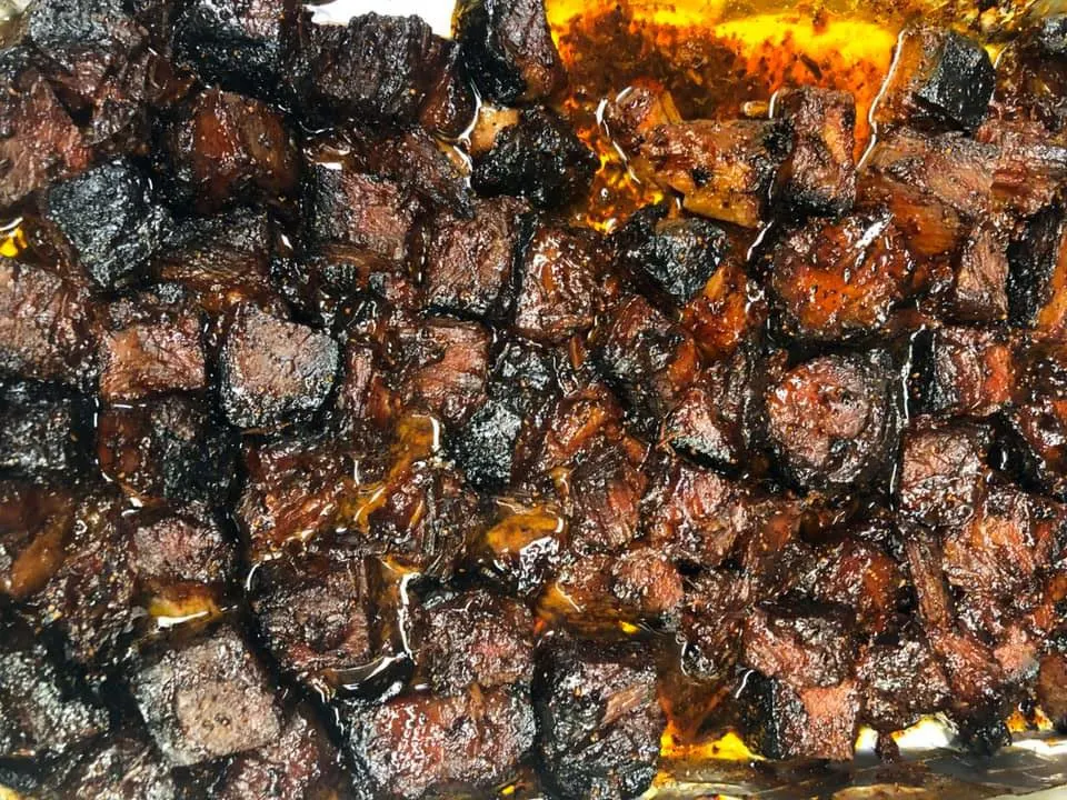 Cubes of brisket browning in a Dutch oven with deep golden edges and sizzling oil