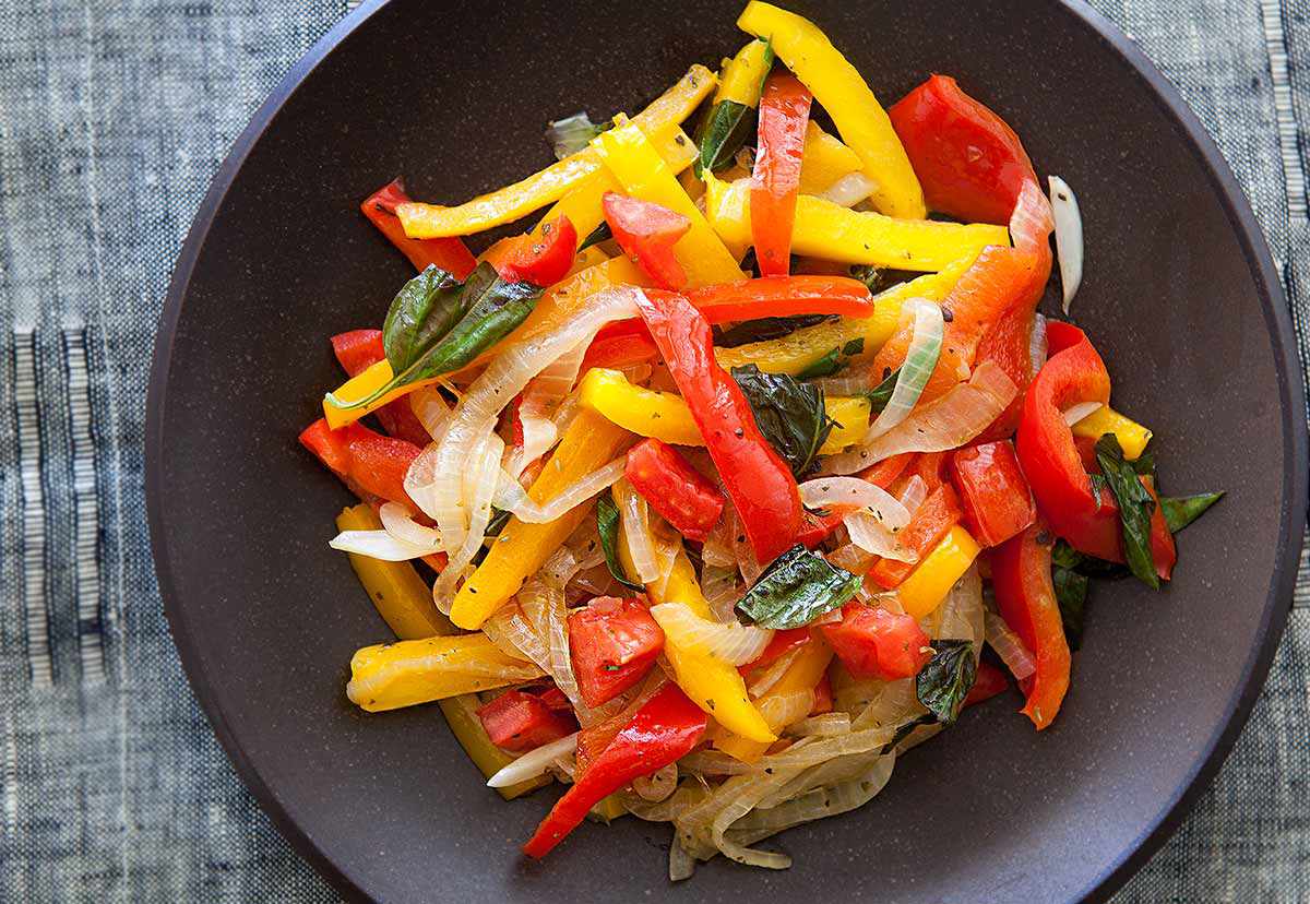 Diced onion and green bell pepper sautéing in a Dutch oven