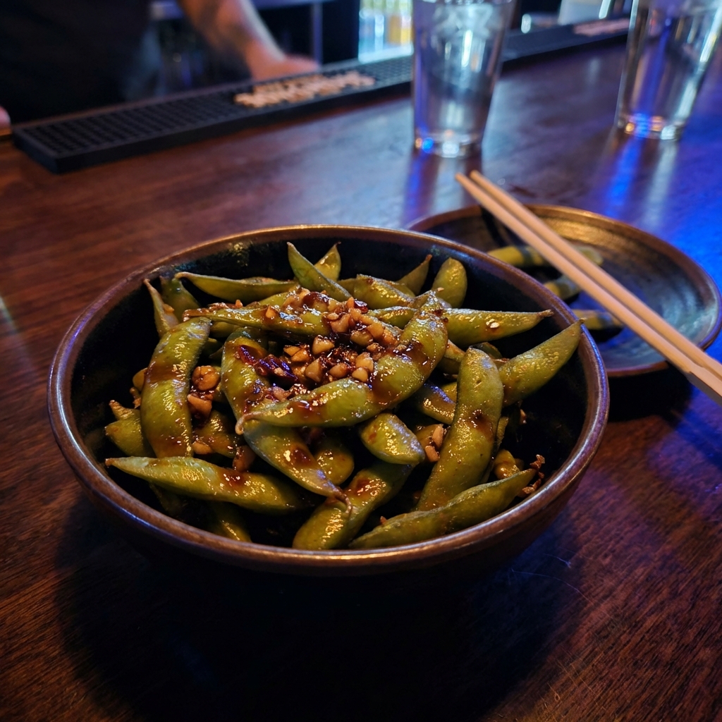 Edamame in a bowl with glossy soy garlic sauce