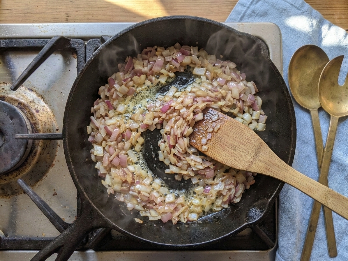 Finely chopped onions sautéing in melted butter in a wide skillet
