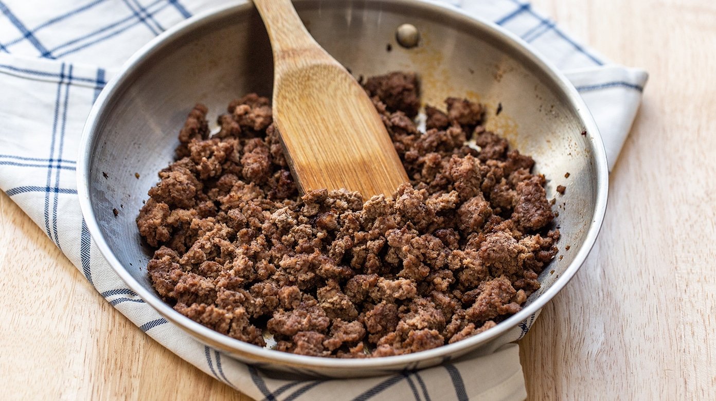 Finished skillet browned ground beef with crisp browned bits and minimal visible grease in the pan