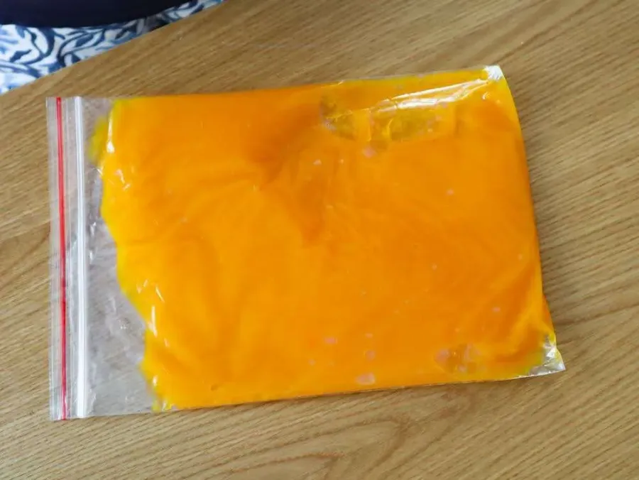 Flat freezer bags filled with pumpkin purée stacked in a freezer
