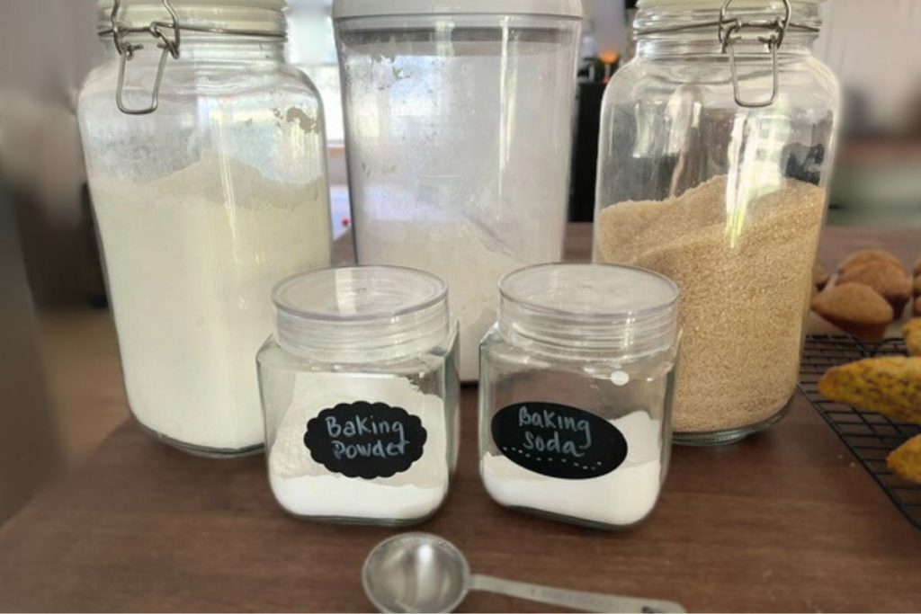 Flour, sugar, baking powder, salt, an egg, vanilla, oil, and a measuring cup of water arranged on a clean kitchen counter