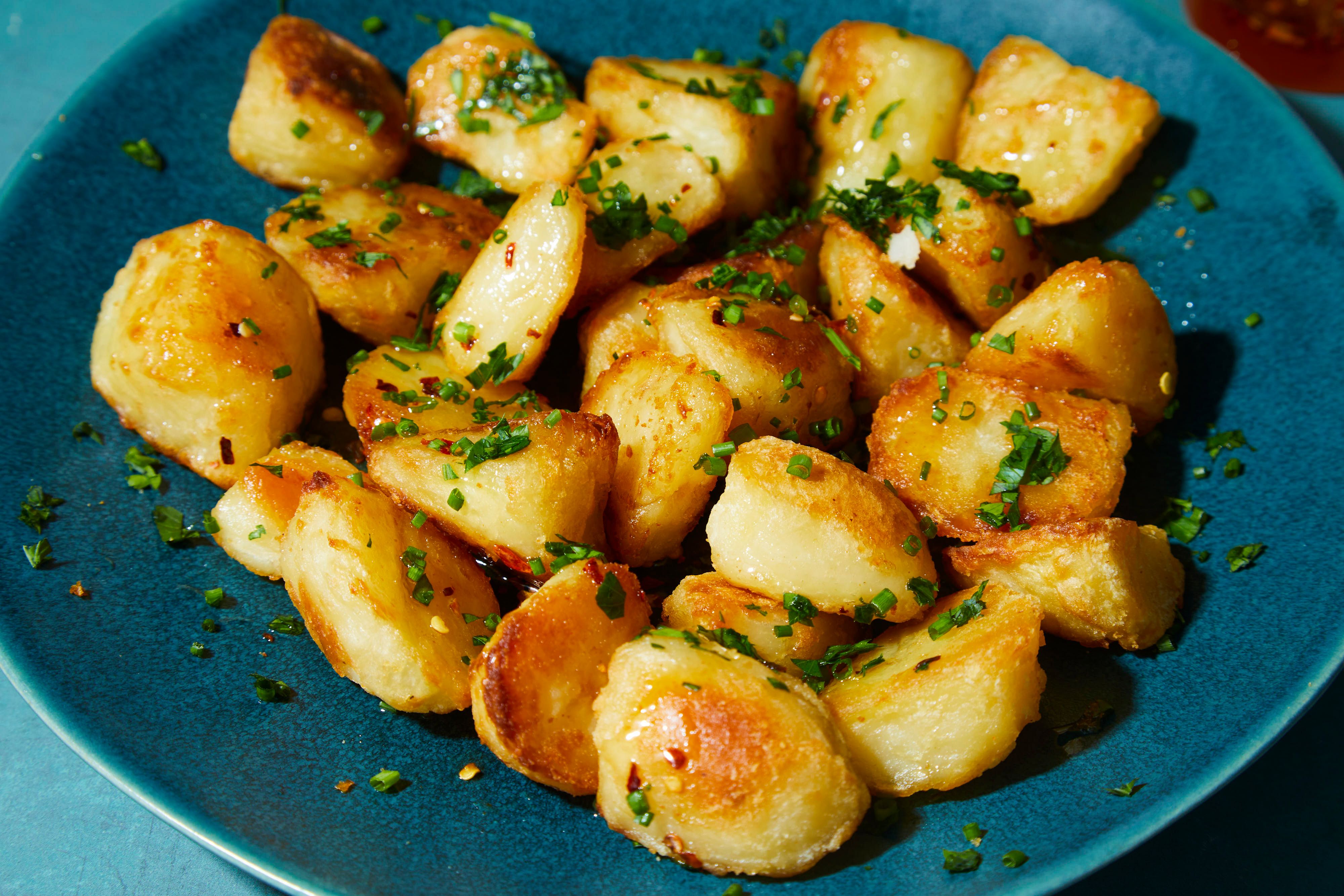 Golden-browned potato pieces with crisp edges cooking in a skillet before the sauce is added
