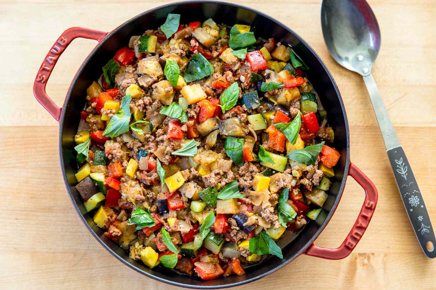Ground beef browning in a skillet with small crumbles and golden bits forming on the bottom