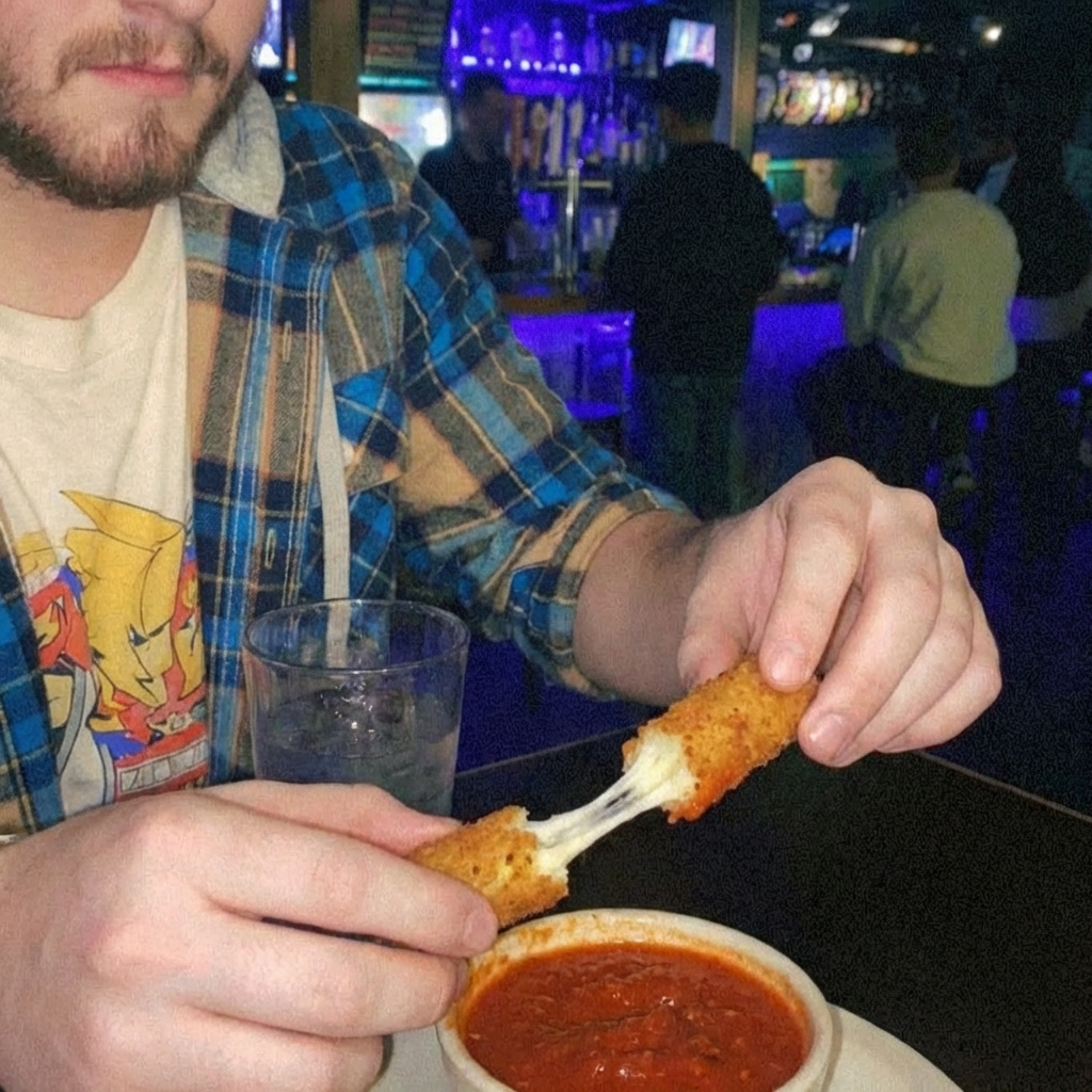 Hands dipping a crispy mozzarella stick into marinara with visible cheese pull