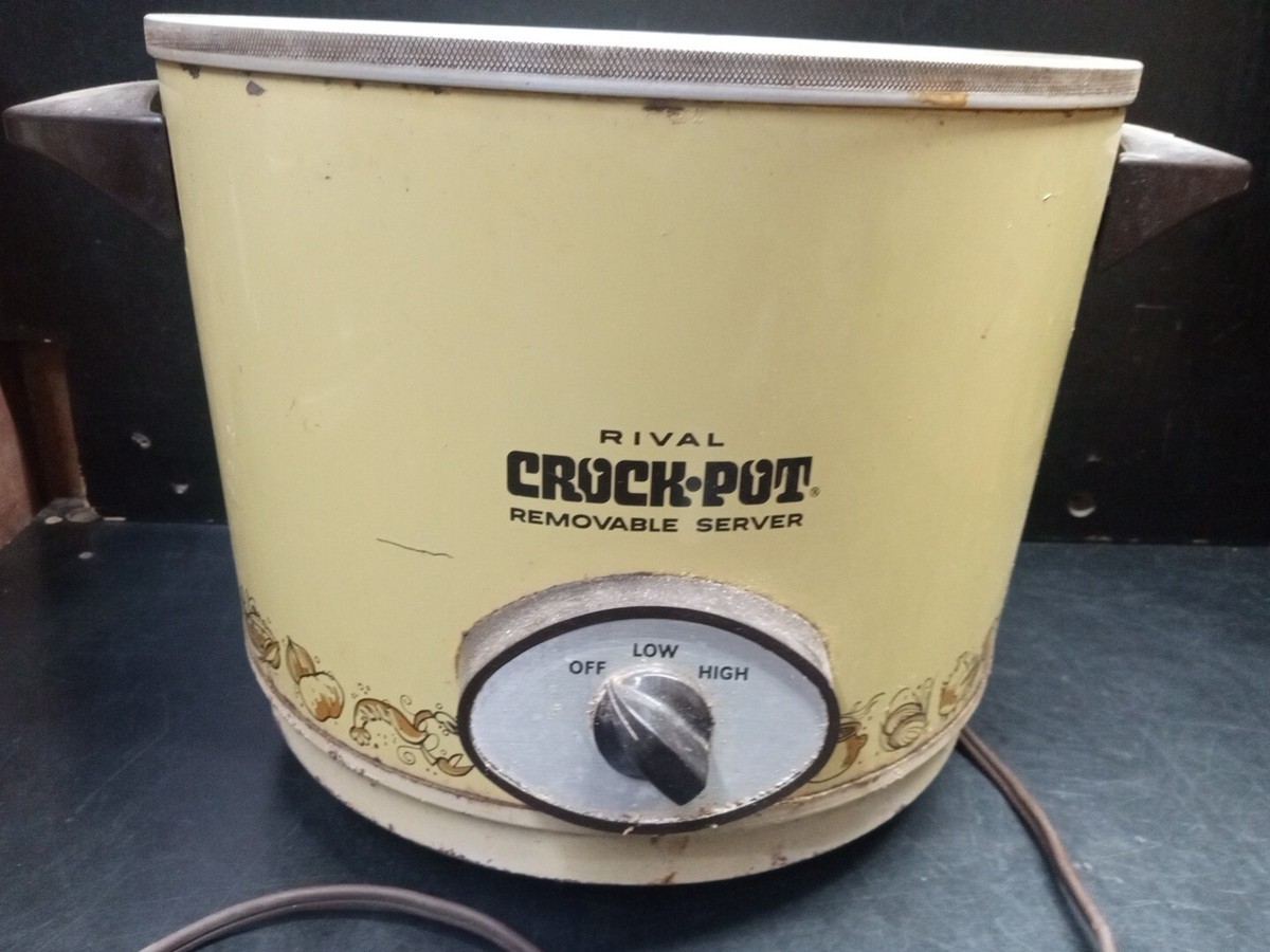 Hands lowering a ceramic slow cooker insert into the metal heating base on a kitchen counter