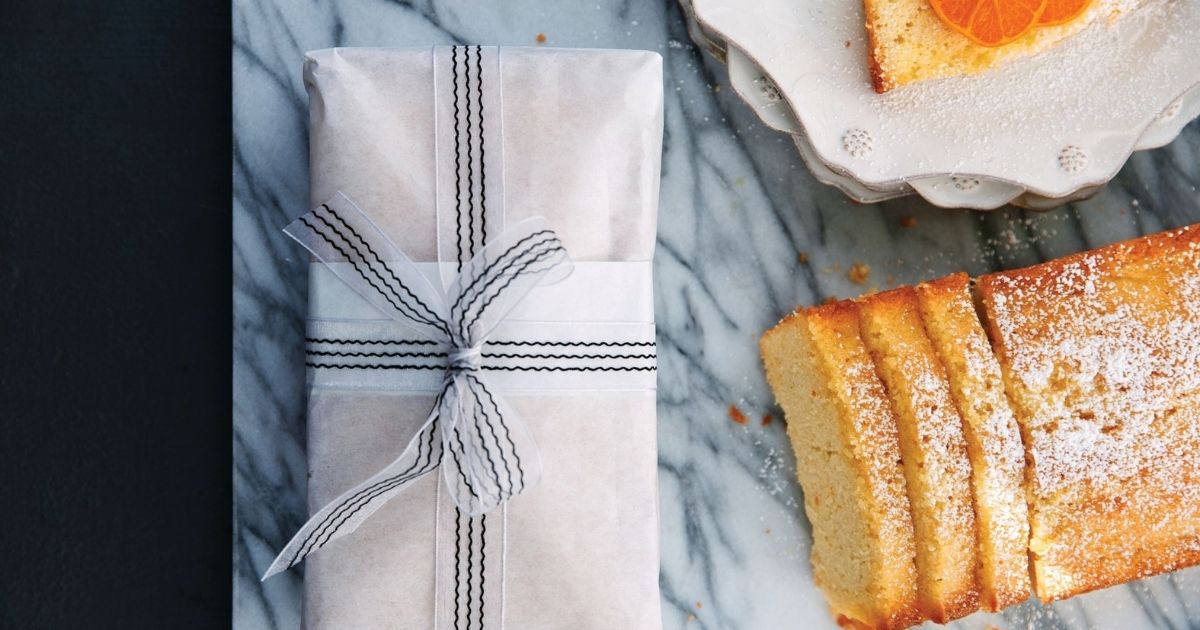 Individually wrapped slices of pound cake in plastic wrap and foil on a kitchen counter, ready to be placed into a freezer bag