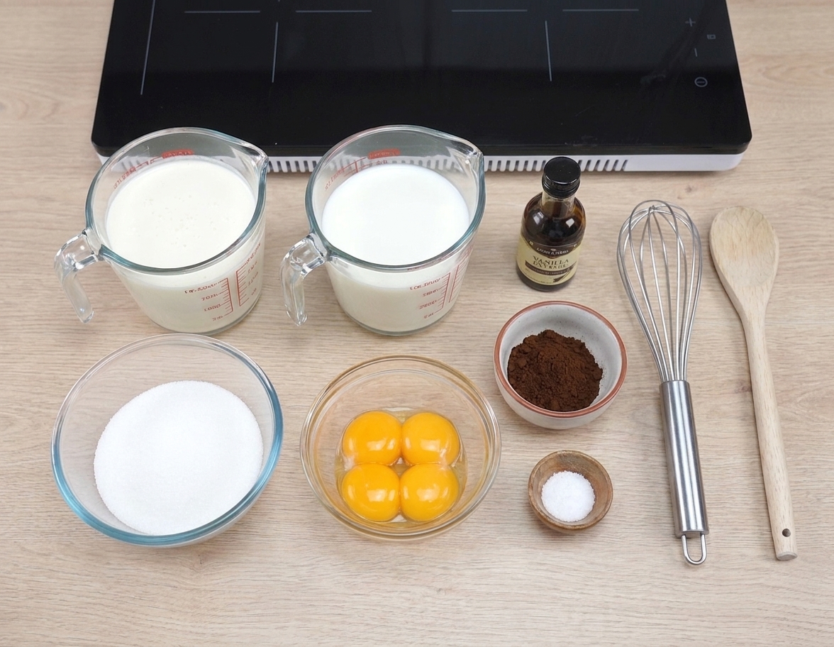 Ingredients for coffee ice cream laid out on a bright kitchen counter including cream, milk, sugar, egg yolks, espresso powder, vanilla, and salt
