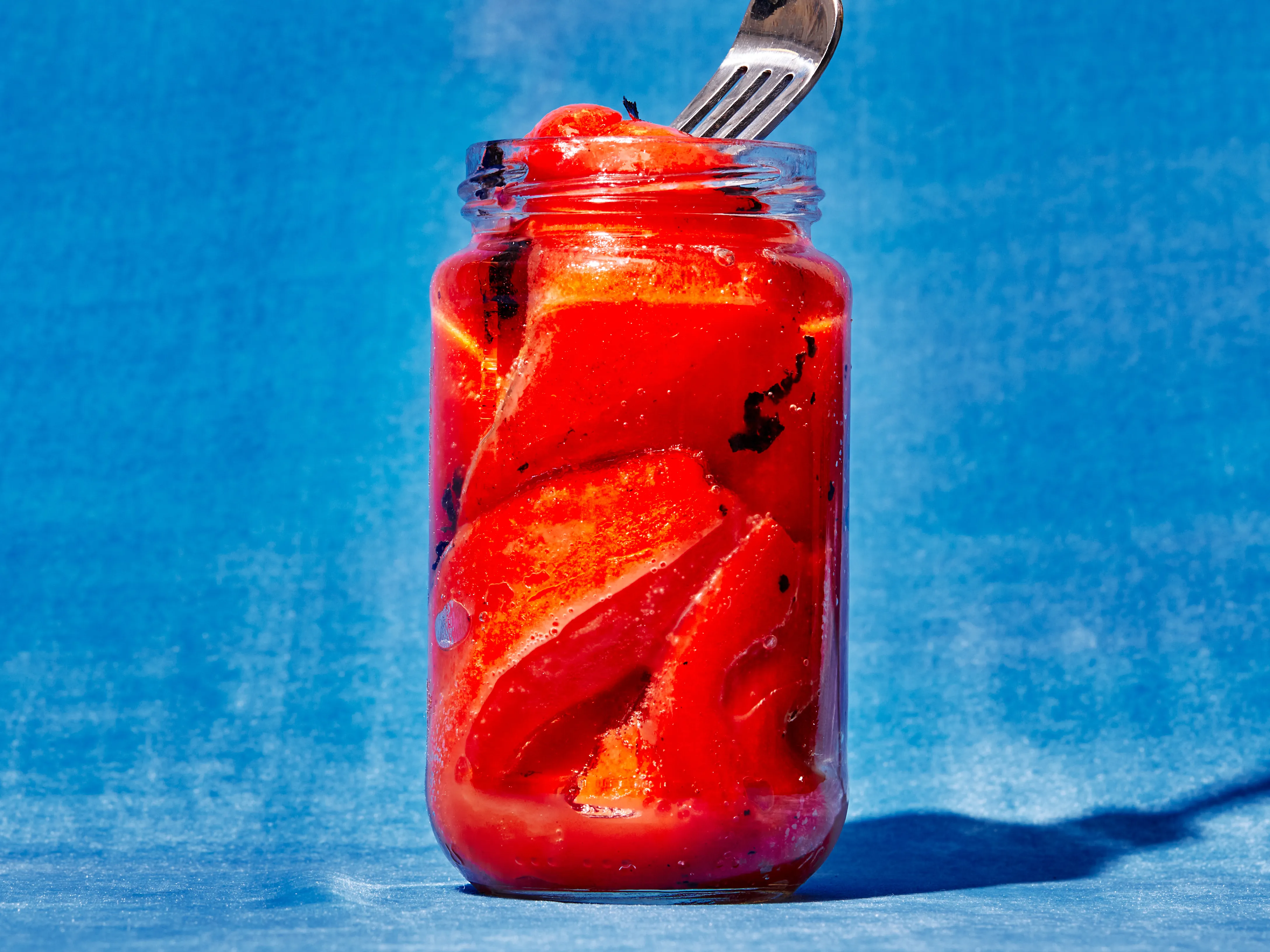 Jarred roasted red peppers, mayonnaise, lemon, garlic, and smoked paprika arranged on a tidy kitchen counter in warm natural light