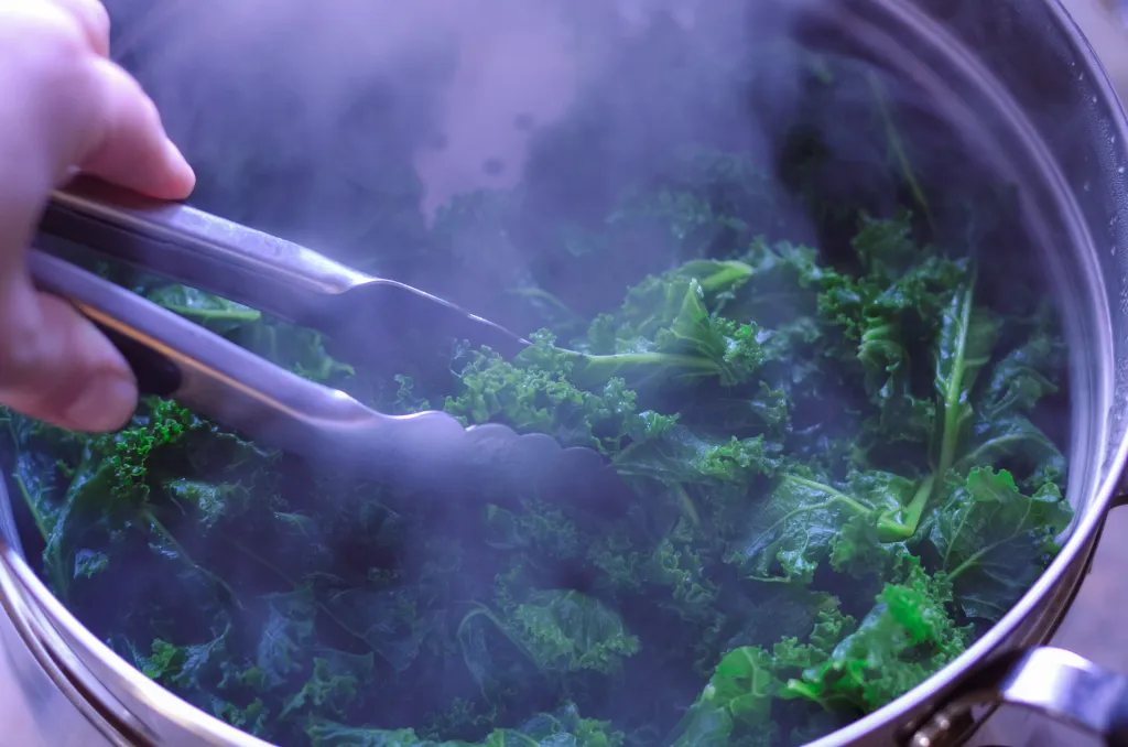 Kale leaves being blanched in a pot of boiling water on a stovetop with steam rising