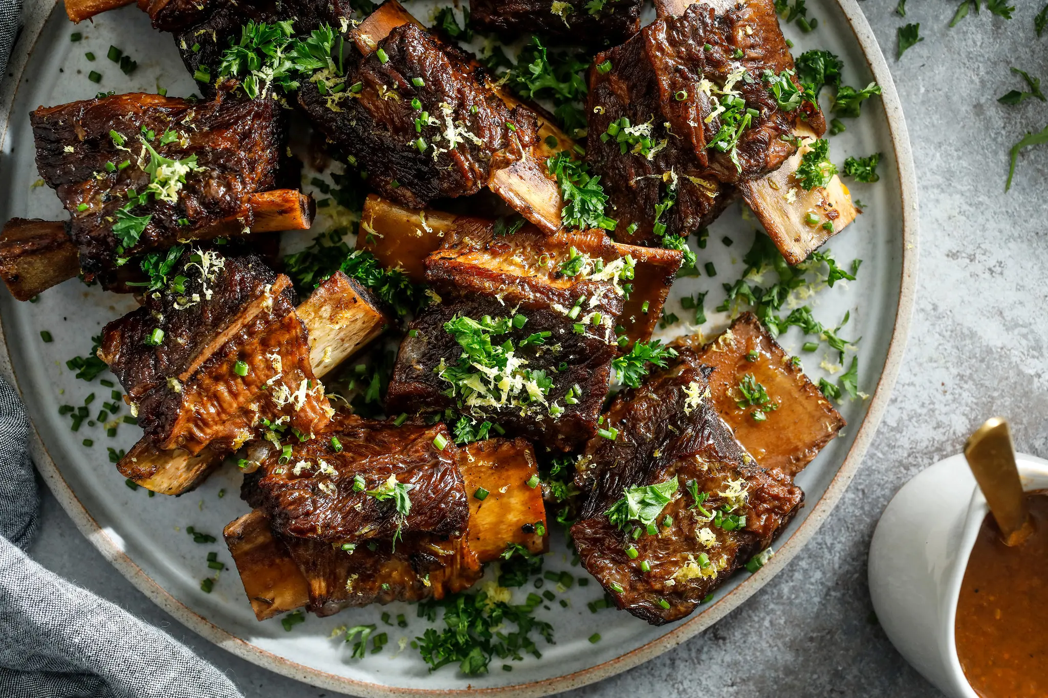 Leftover beef short ribs and gravy stored in a glass container, ready to reheat