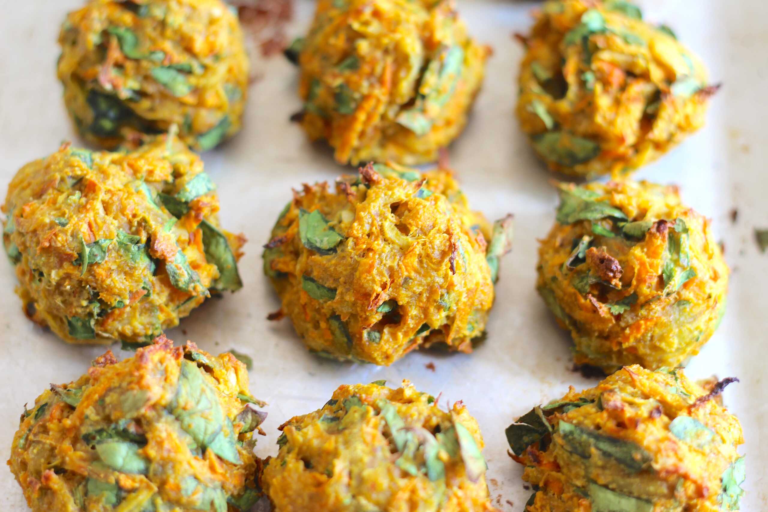 Leftover onion pakora arranged in a single layer on a parchment lined baking sheet ready to reheat in the oven