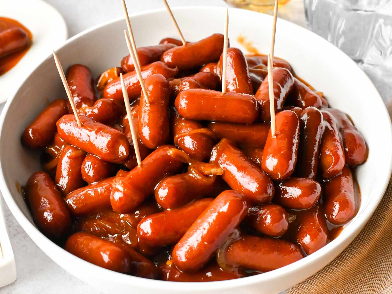 Lil smokies, brown sugar, ketchup, barbecue sauce, Dijon mustard, apple cider vinegar, and spices arranged on a tidy kitchen counter