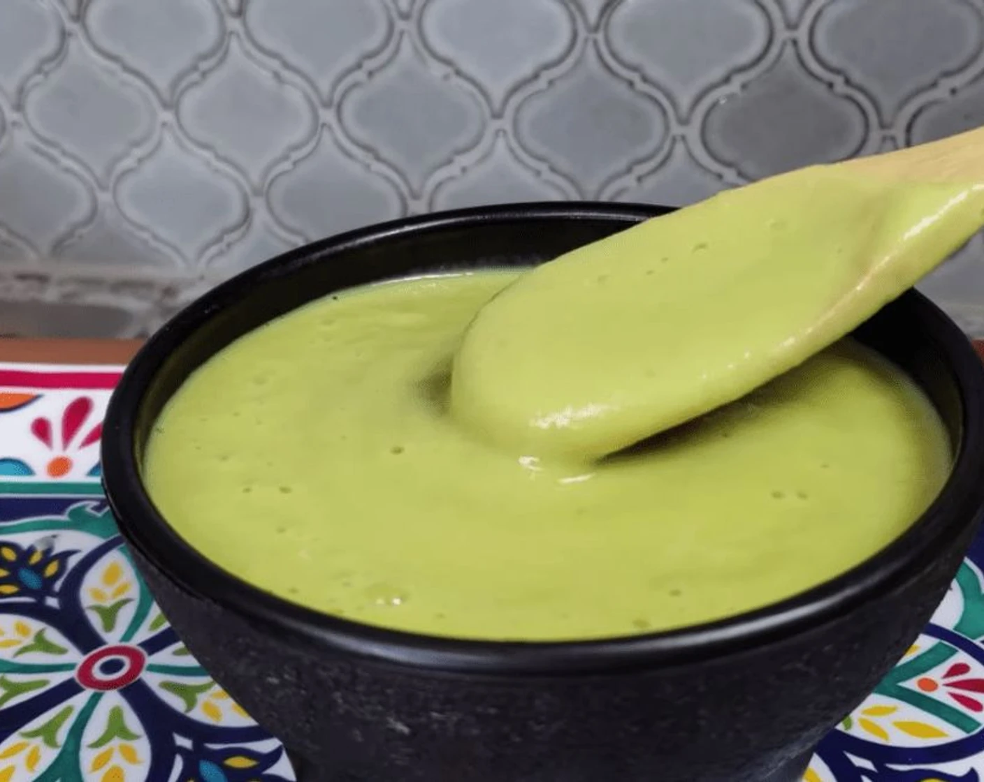 Lime, cilantro, cubed cream cheese, and an open jar of salsa verde arranged on a kitchen counter