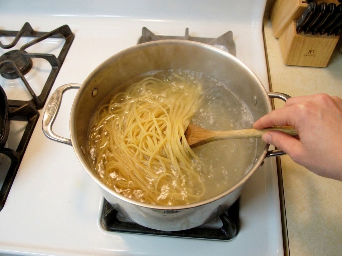 Linguine boiling in a large pot of salted water on a home stove