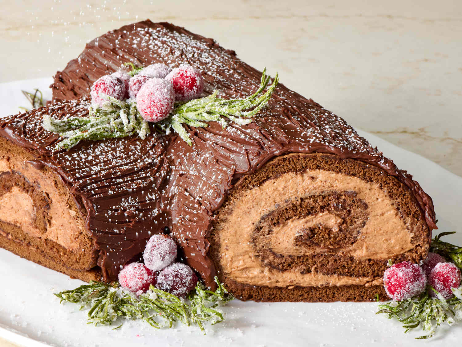Measured ingredients for Bûche de Noël on a kitchen counter including eggs, cocoa powder, flour, sugar, butter, vanilla, mascarpone, heavy cream, and chocolate