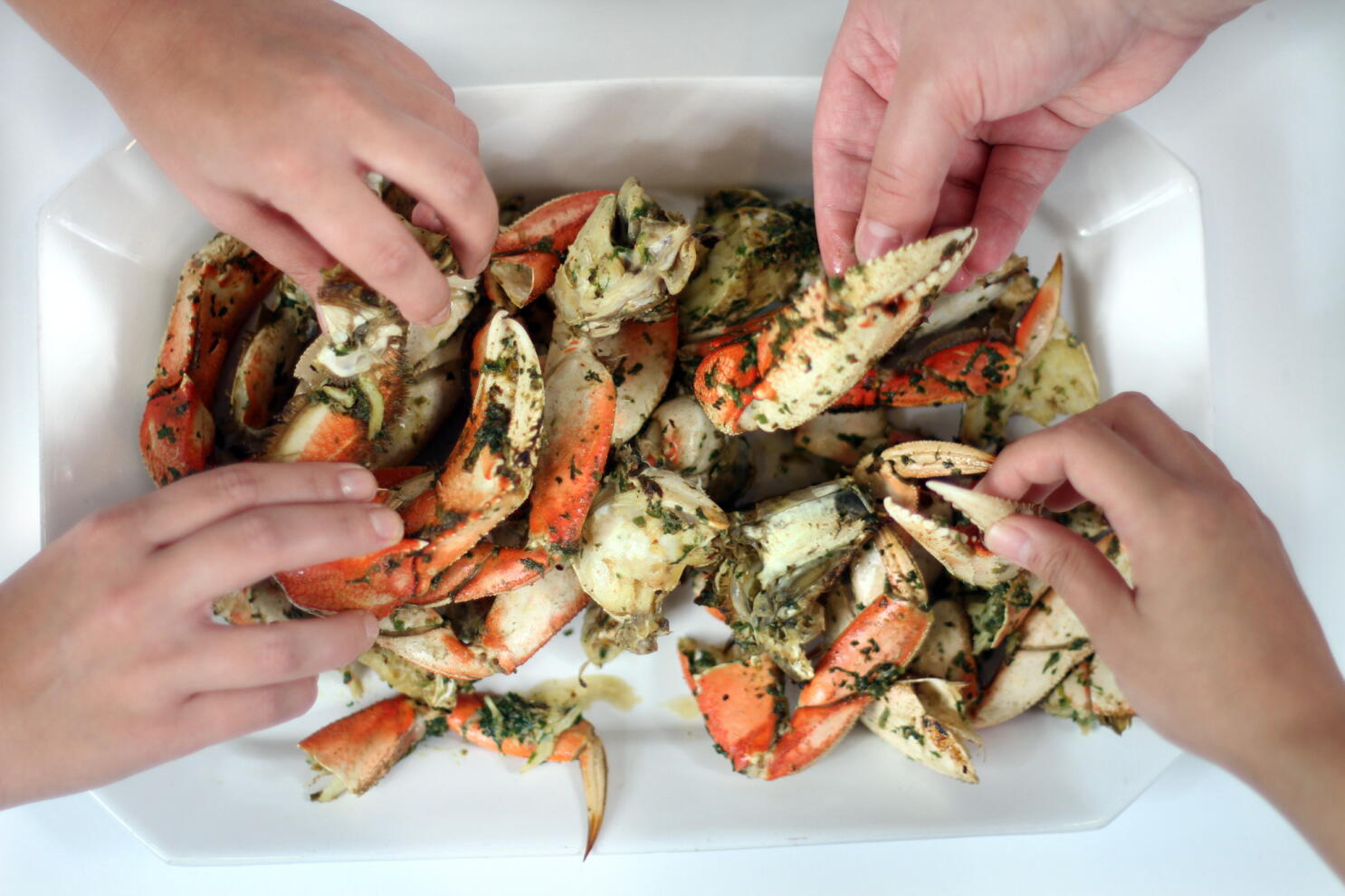 Measured ingredients for garlic butter Dungeness crab including butter, minced garlic, lemon wedges, parsley, and seasoning arranged on a clean kitchen counter