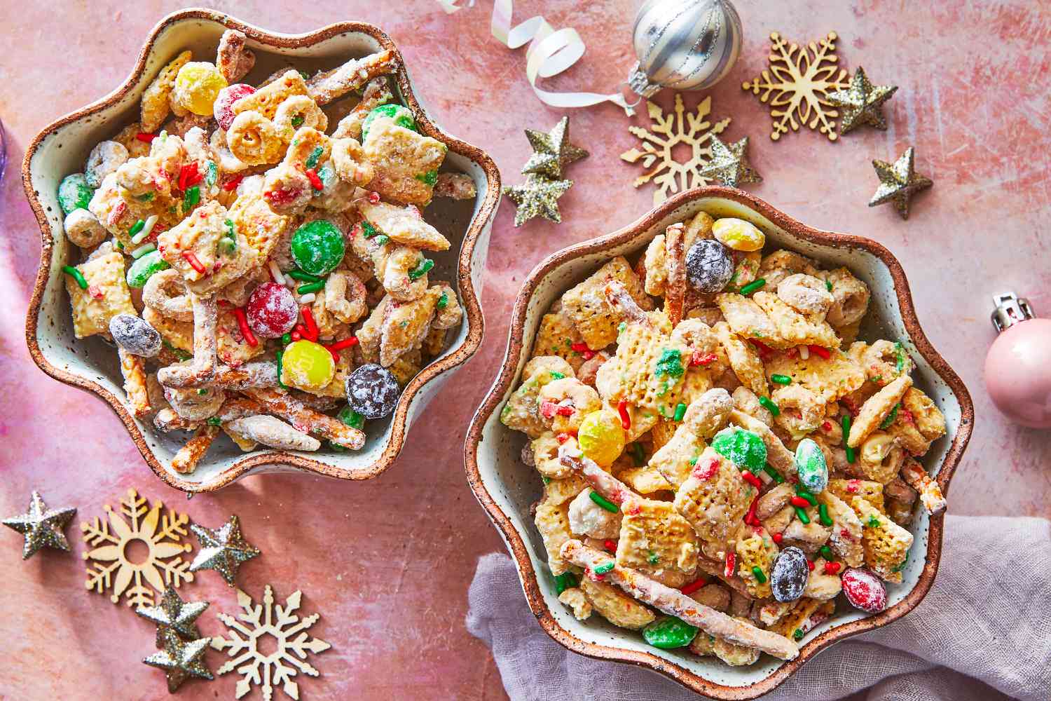 Measured ingredients for reindeer food including rolled oats, granulated sugar, red and green sprinkles, and edible glitter arranged in small bowls on a kitchen counter