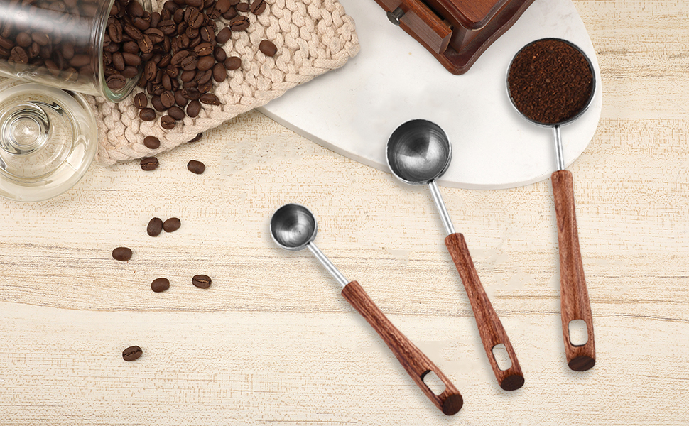 Measuring spoons with cocoa powder and sugar on a kitchen counter next to a small bowl of salt and a bottle of vanilla extract