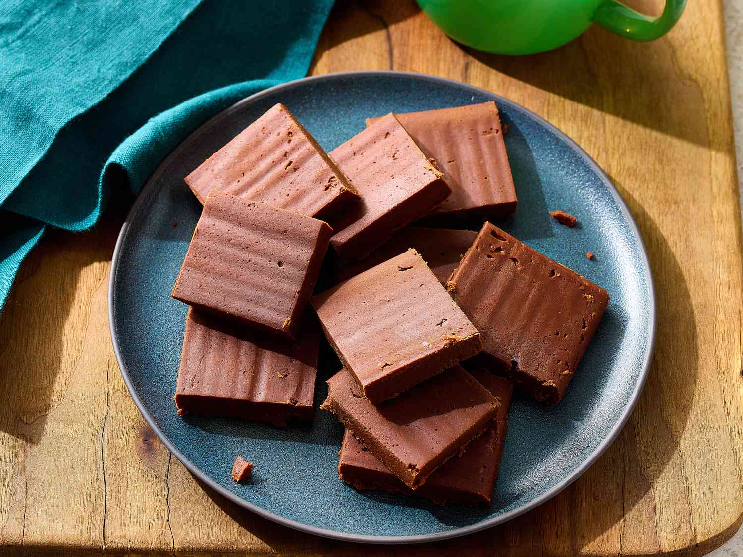 Neatly sliced marshmallow fluff fudge squares on parchment paper with a chef knife beside them