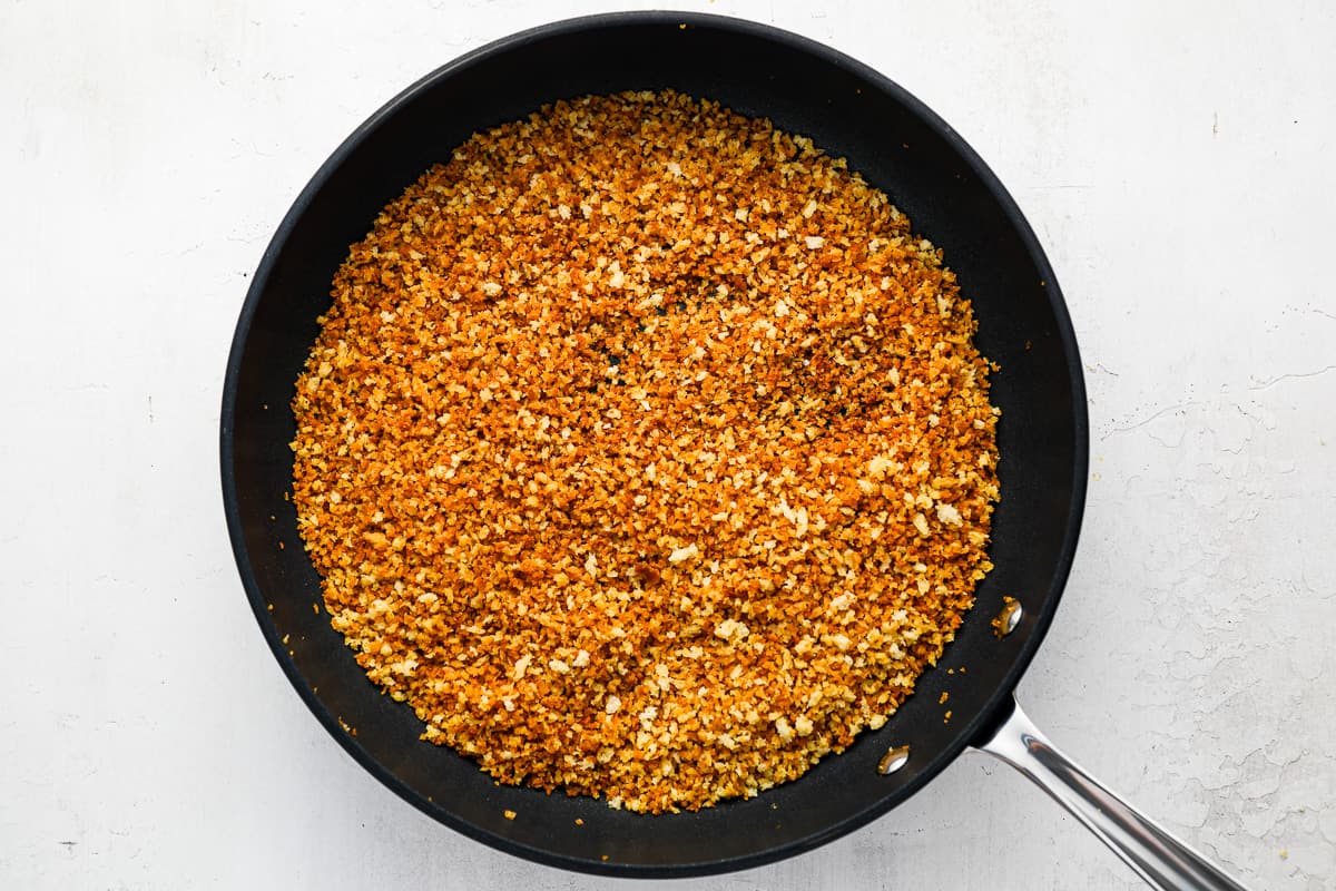Panko breadcrumbs toasting in a skillet with melted butter until golden brown on a stovetop