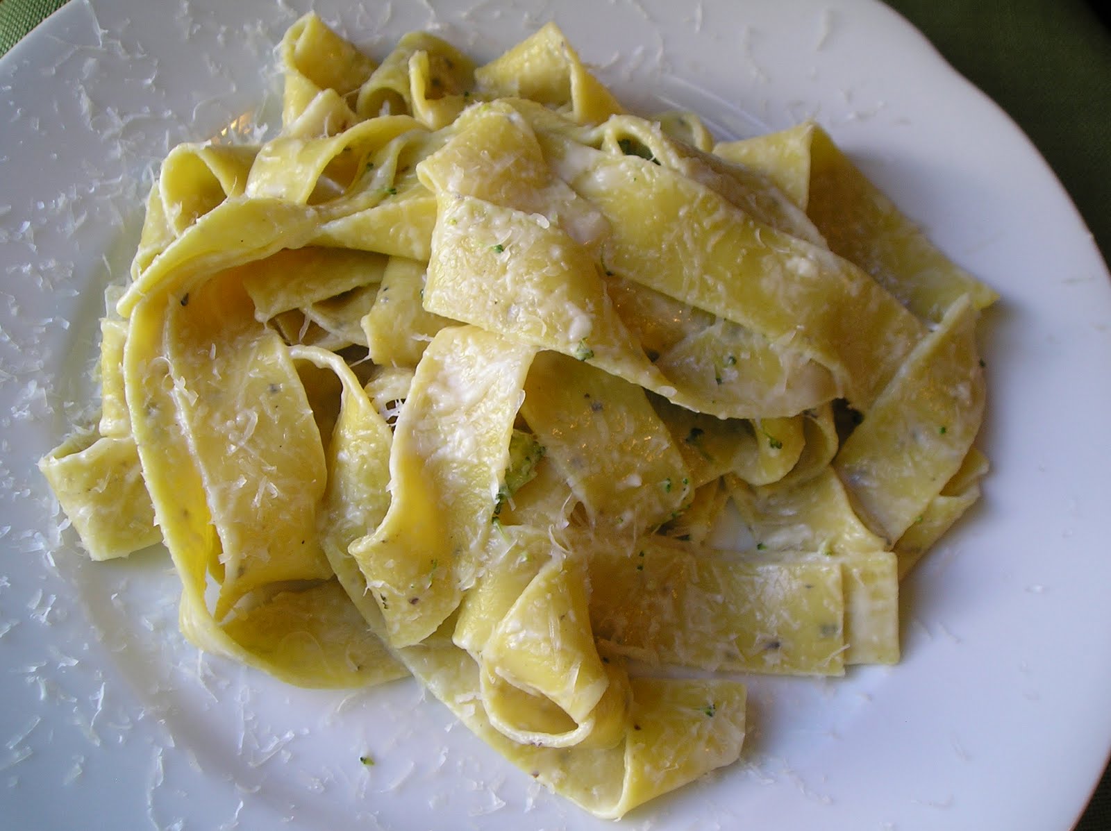 Pappardelle pasta, lemons, garlic, Parmesan, cream, butter, olive oil, and a small bowl of breadcrumbs arranged on a light kitchen counter