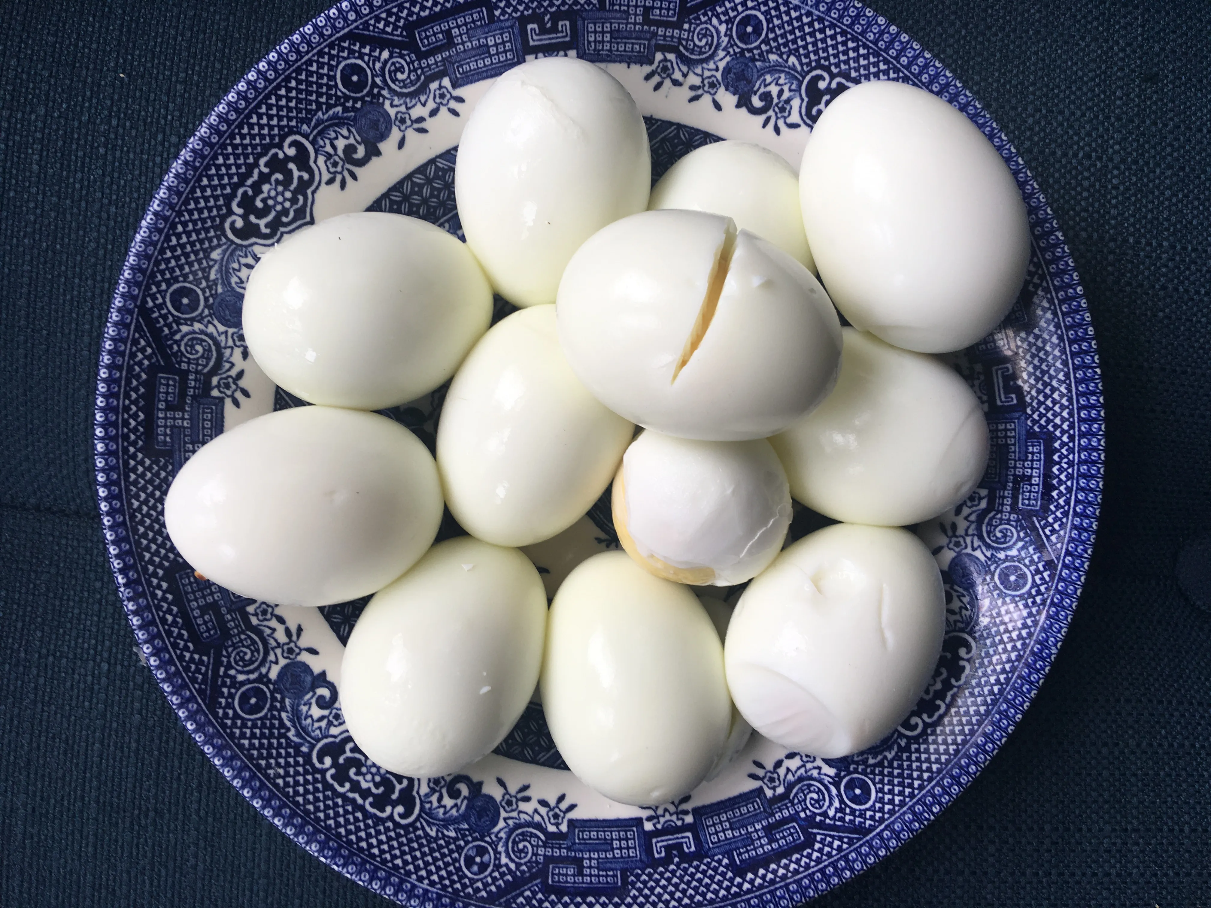 Peeled hard boiled eggs resting in a bowl on a kitchen counter, ready to be chopped