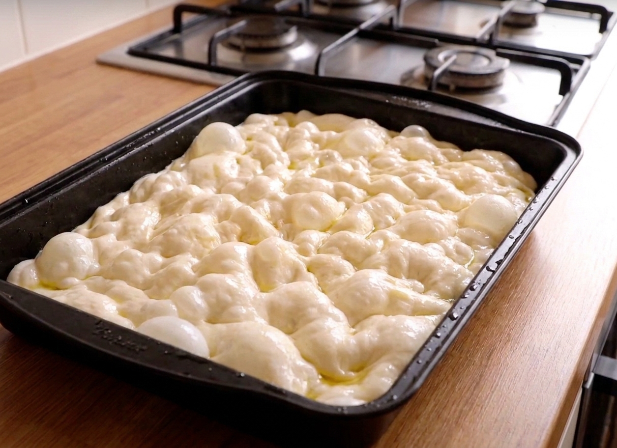 Risen focaccia dough with bubbles