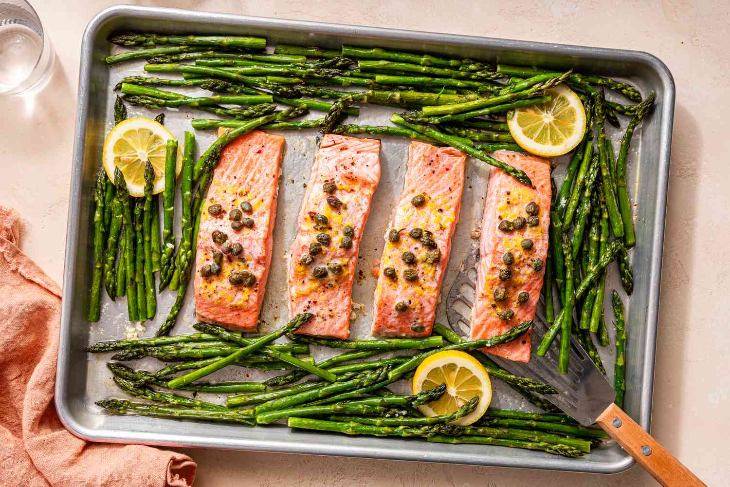 Salmon fillets arranged on a parchment lined sheet pan, ready to be seasoned