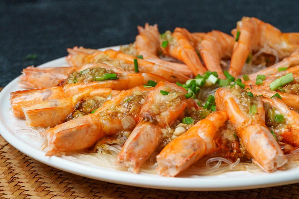 Shrimp shells simmering in a small saucepan with onion and garlic to make quick seafood stock on a stovetop