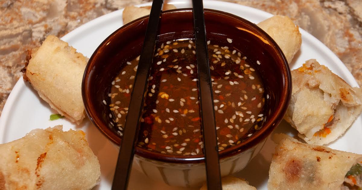 Small bowls of soy sauce, rice vinegar, sesame oil, and chili crisp on a kitchen counter ready for dipping sauce