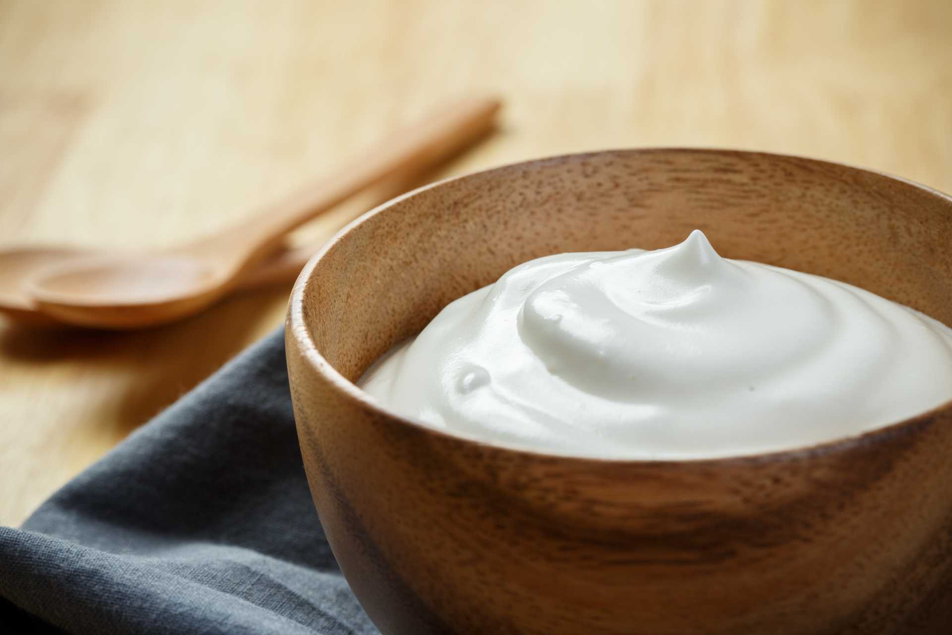 Sour cream, heavy cream, lime, and salt measured out in small bowls on a bright kitchen counter