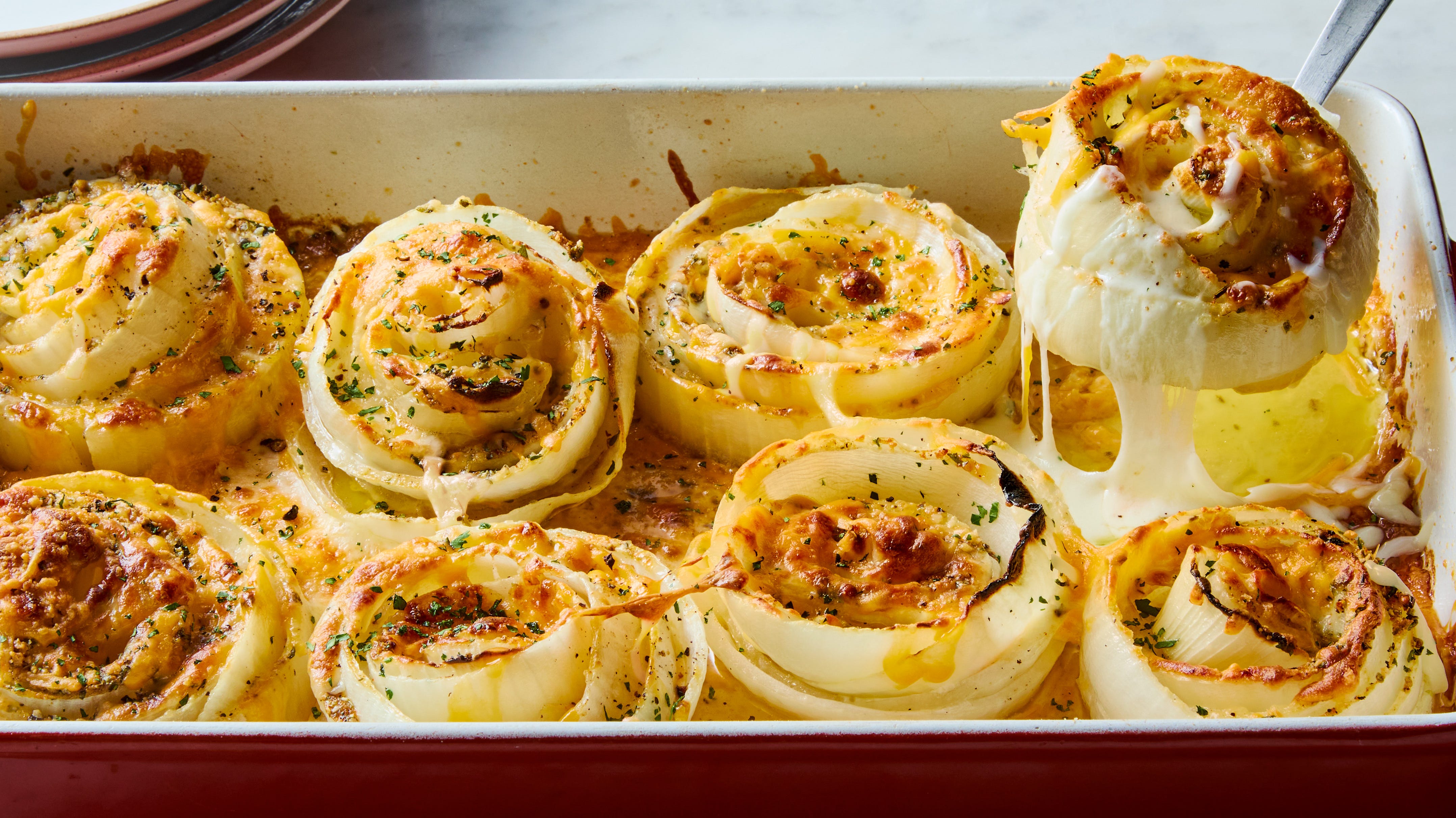 Sweet onions, shredded cheddar, shredded mozzarella, butter, and seasonings arranged on a light kitchen counter, ready to prep
