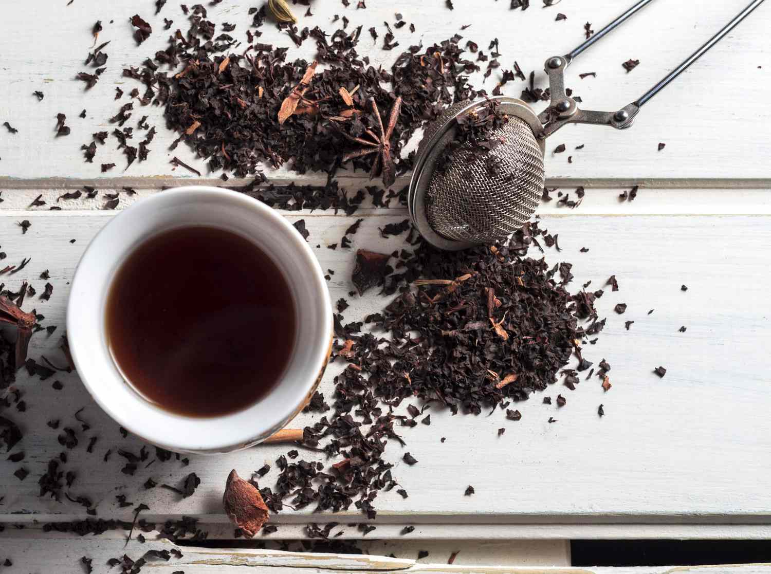 Tea bags steeping in a heatproof measuring cup on a kitchen counter with steam rising gently