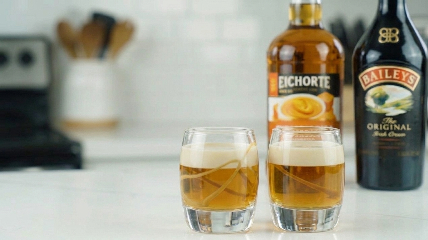 Two finished layered Buttery Nipple shots with distinct golden and cream layers