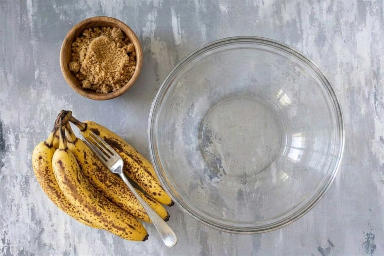 Very ripe speckled bananas on a light stone kitchen counter next to a mixing bowl